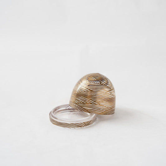 The acrylic wave box with its lid slightly removed and skewed, showcasing the polished internal chamber and the continuous gold lines running along the rim.