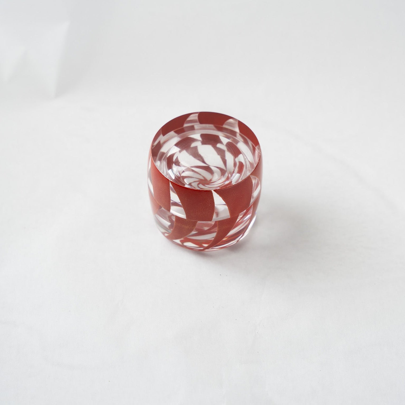 Directly from above view of the acrylic small box, displaying a perfect concentric geometry where the exterior spirals merge into a fluid optical illusion.