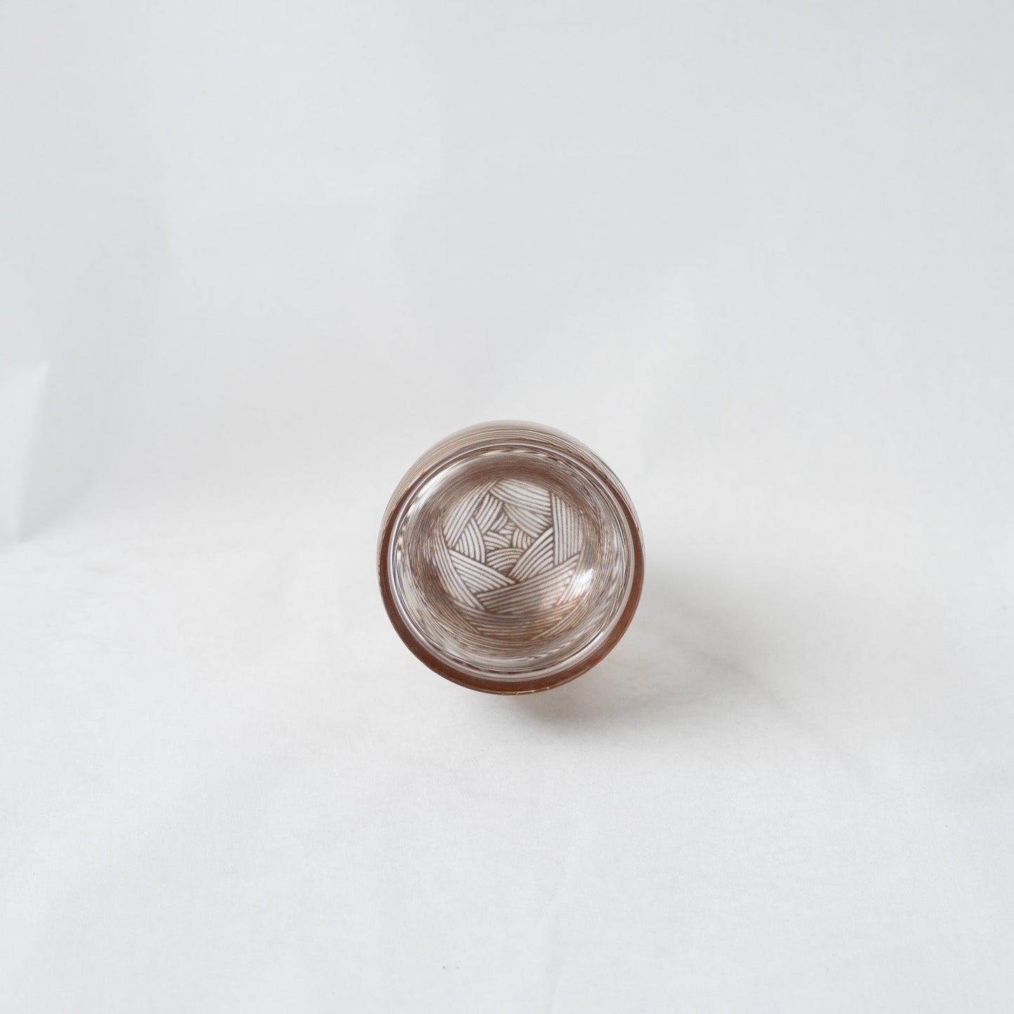 A direct top-down view looking through the clear acrylic dome, illustrating the kaleidoscopic overlapping lines that create a mesmerizing optical illusion of depth.