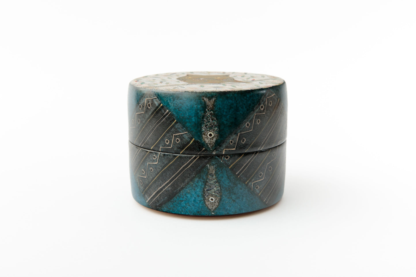 Close-up of blue green glazed japanese ceramic box with carved fish motifs and gold details | wanova