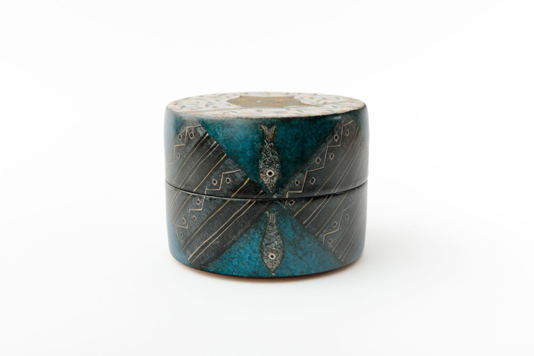 Close-up of blue green glazed japanese ceramic box with carved fish motifs and gold details | wanova