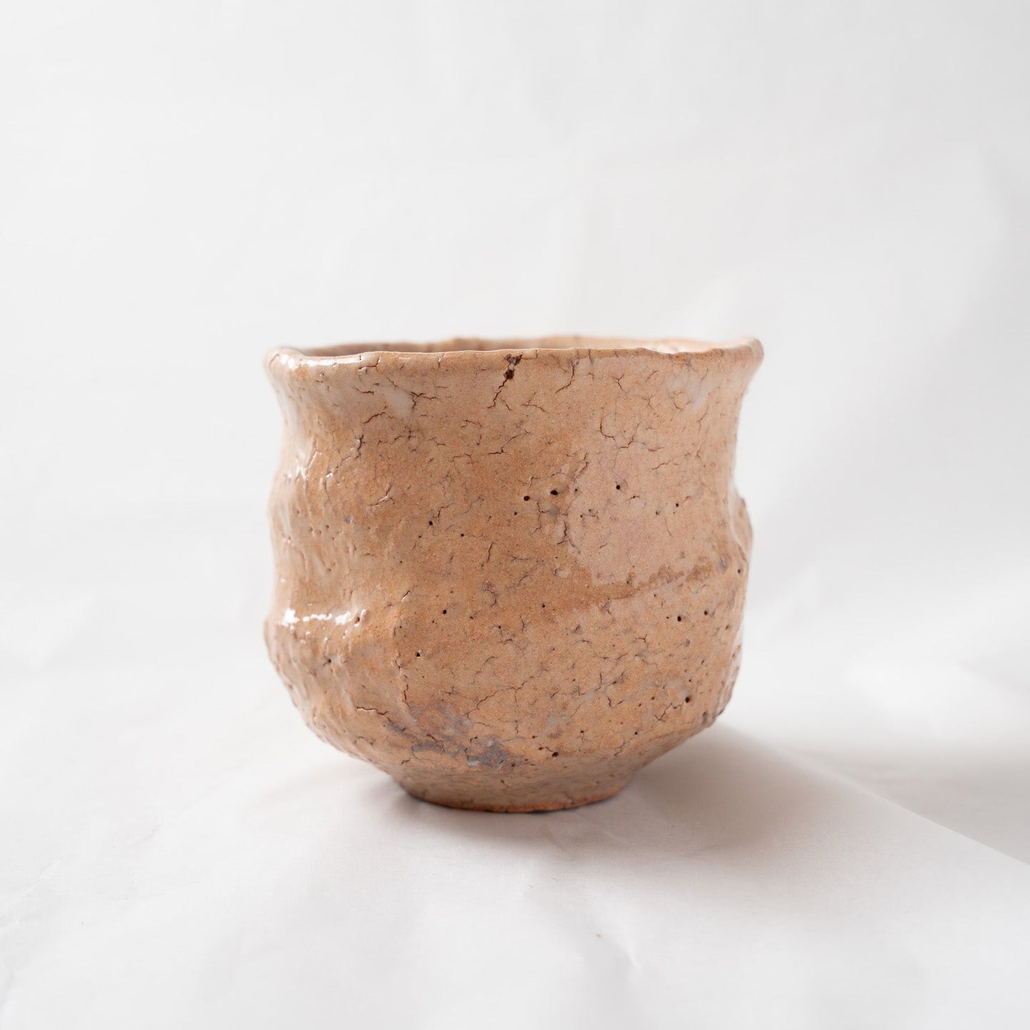 Side profile view of a single "Satoshi" WAN cup against a white background, capturing its full sculptural silhouette with a slightly swelling middle and elegant flared rim.