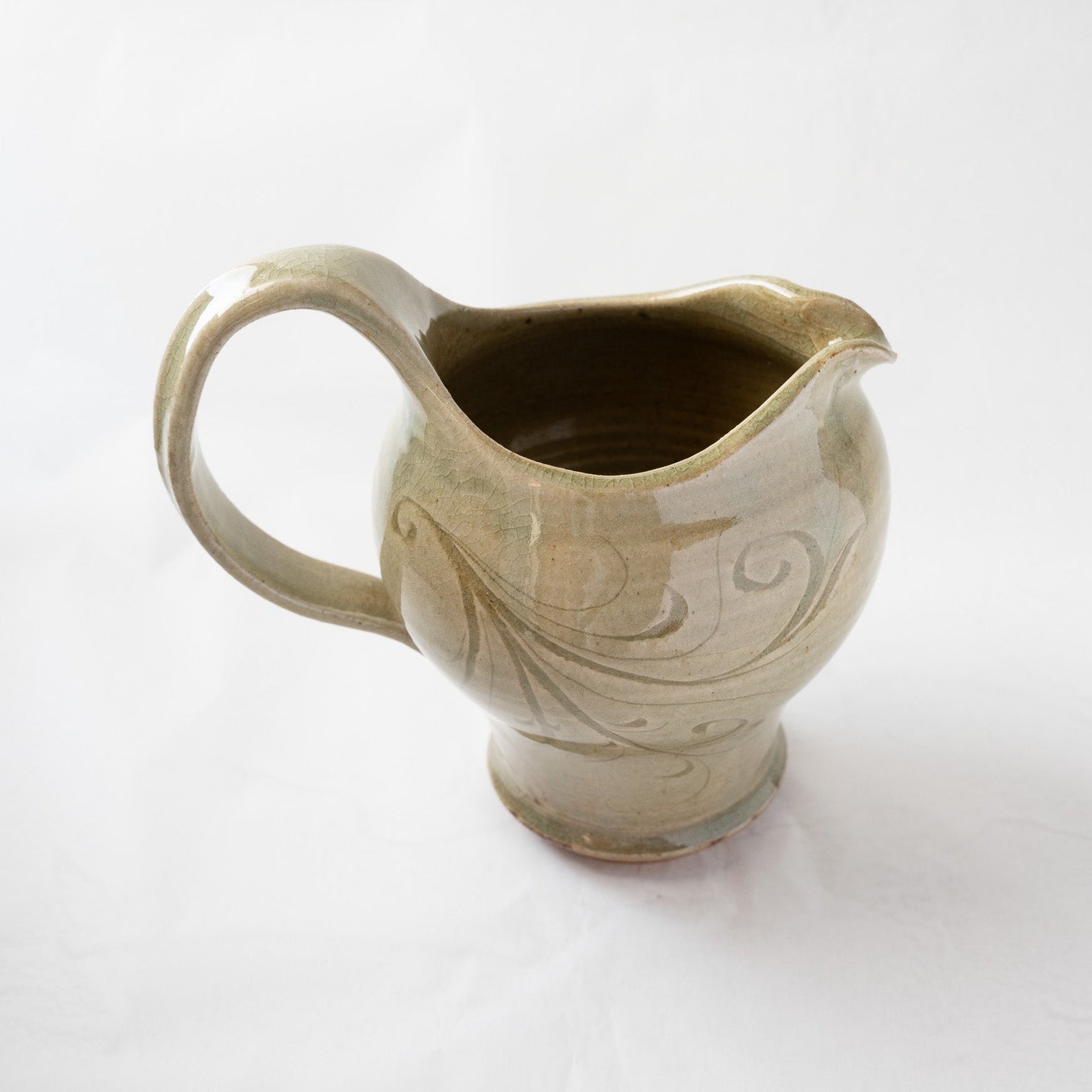 Alternate elevated view of the Toyo Kobayashi ceramic pitcher, displaying the subtle crackle glaze and the organic flow of the incised botanical pattern on the reverse side.