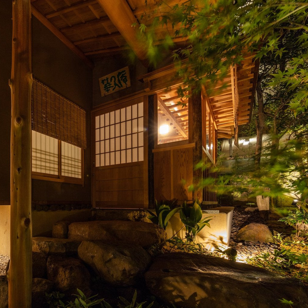 Illuminated entrance and stone garden of a chashitsu at night, Japanese tea house architecture in Roppongi, Tokyo.