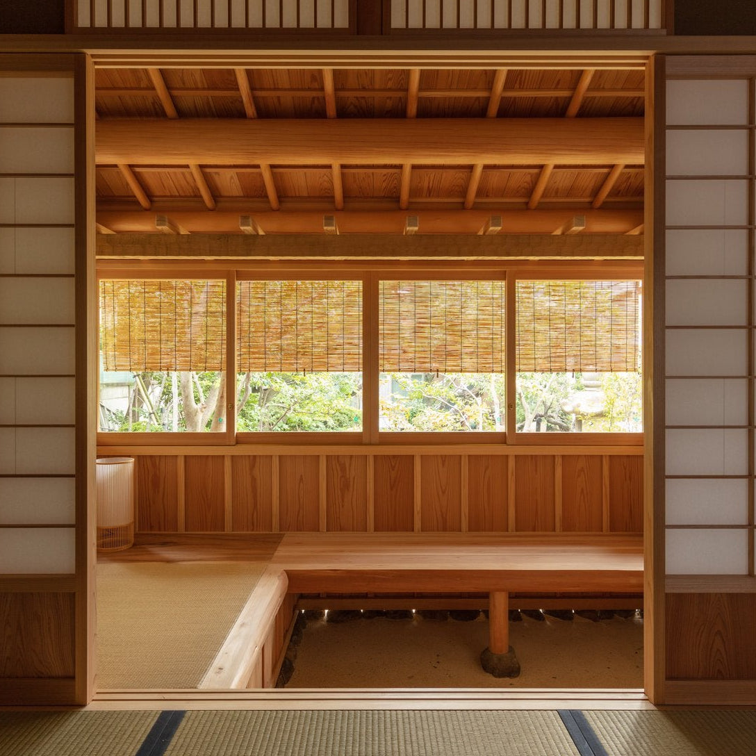 Symmetrical view through shoji onto an engawa bench and garden, a balanced composition of Japanese tea room architecture.