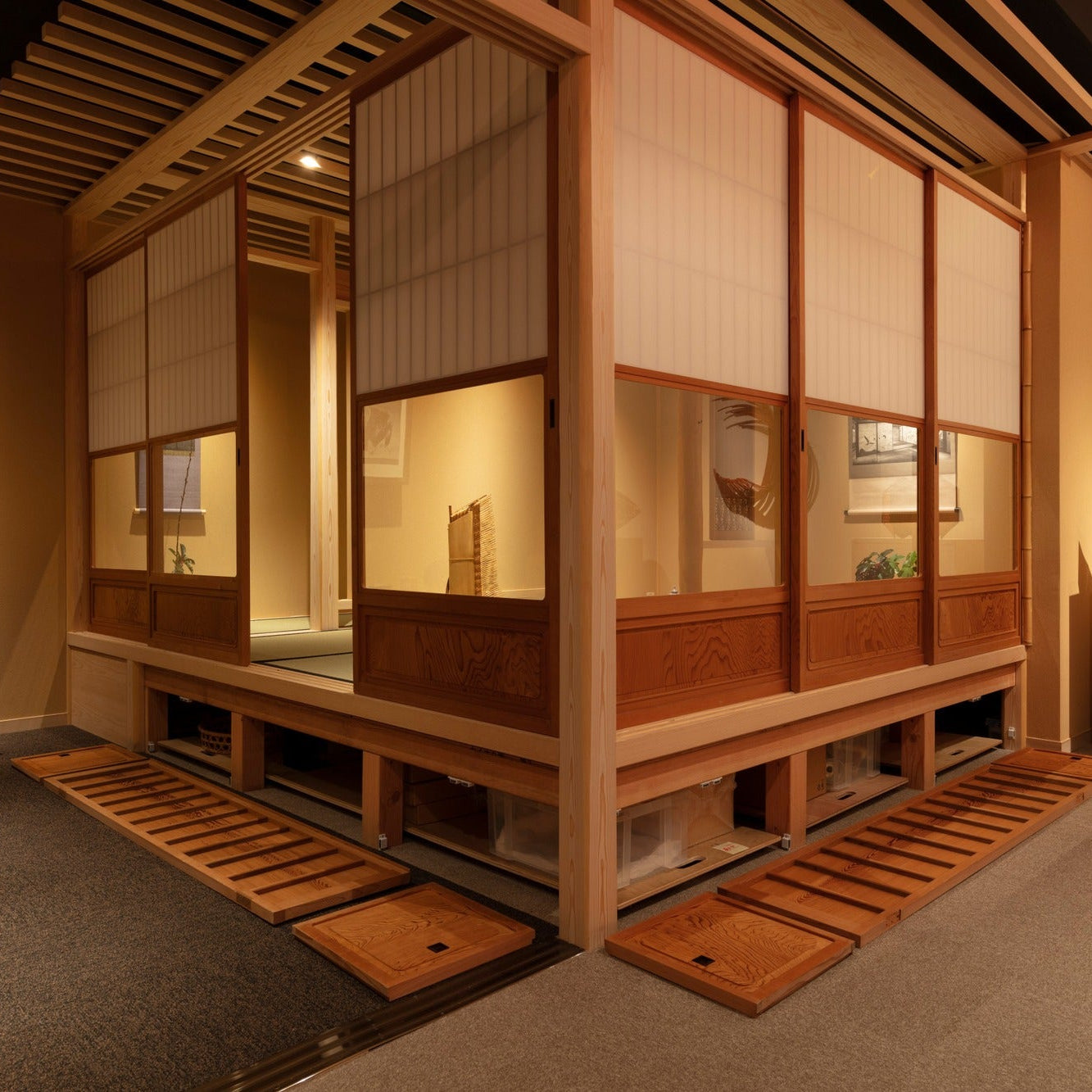Raised tatami platform with removable cedar floorboards revealing hidden storage, a detail of convertible Japanese architecture.