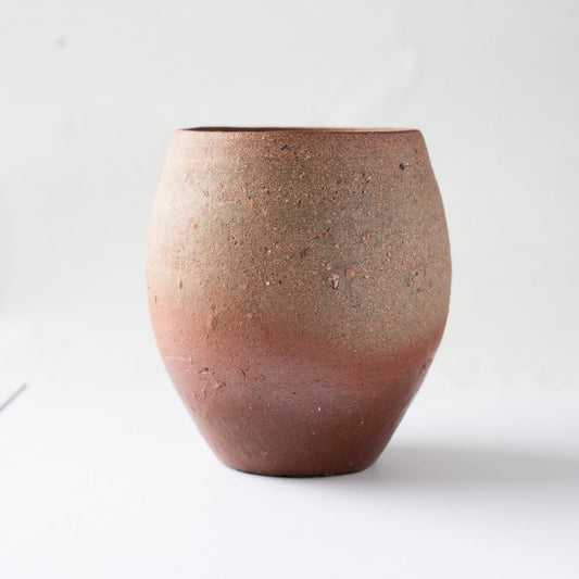 Profile view focusing on the rich dark-brown tones and the slightly irregular, hand-formed rim of the unglazed vessel.