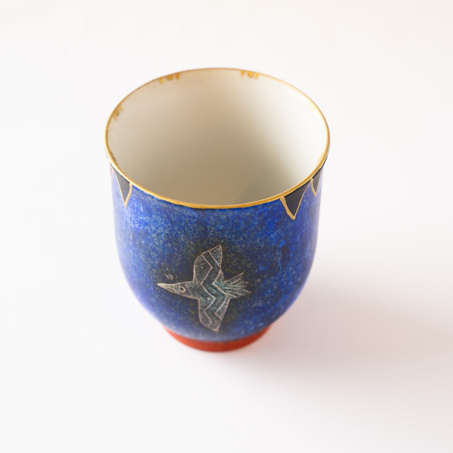 Detailed close-up angle of the YUNOMI cup showing the golden rim decoration and the contrast with the smooth milky-white interior.