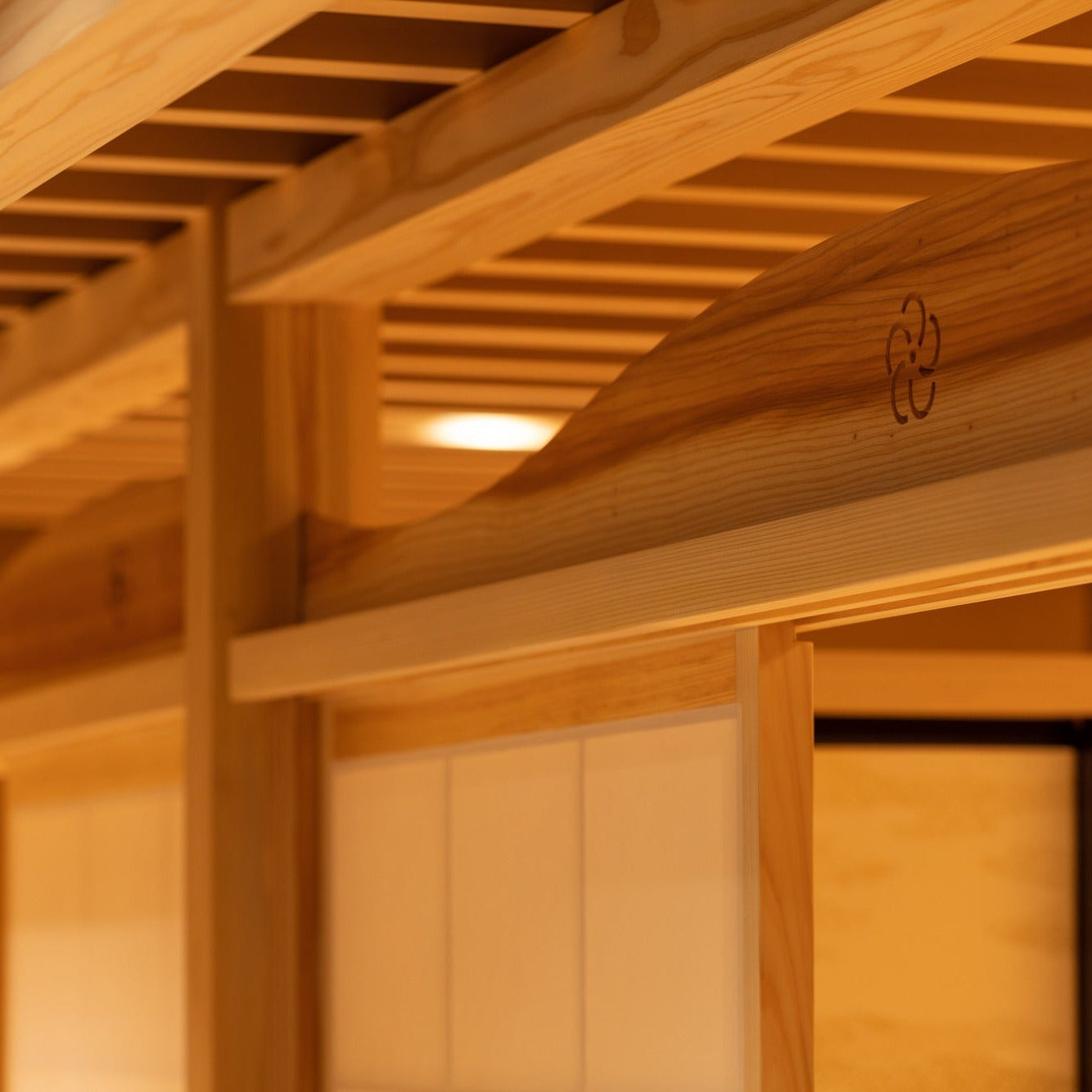 Close-up of slatted cedar ceiling beams with a maker's mark burned into the wood, a detail of Japanese architecture.
