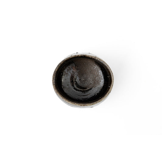 View down into the bowl showing the thick dark glaze and the faint lustre at the centre of the well.