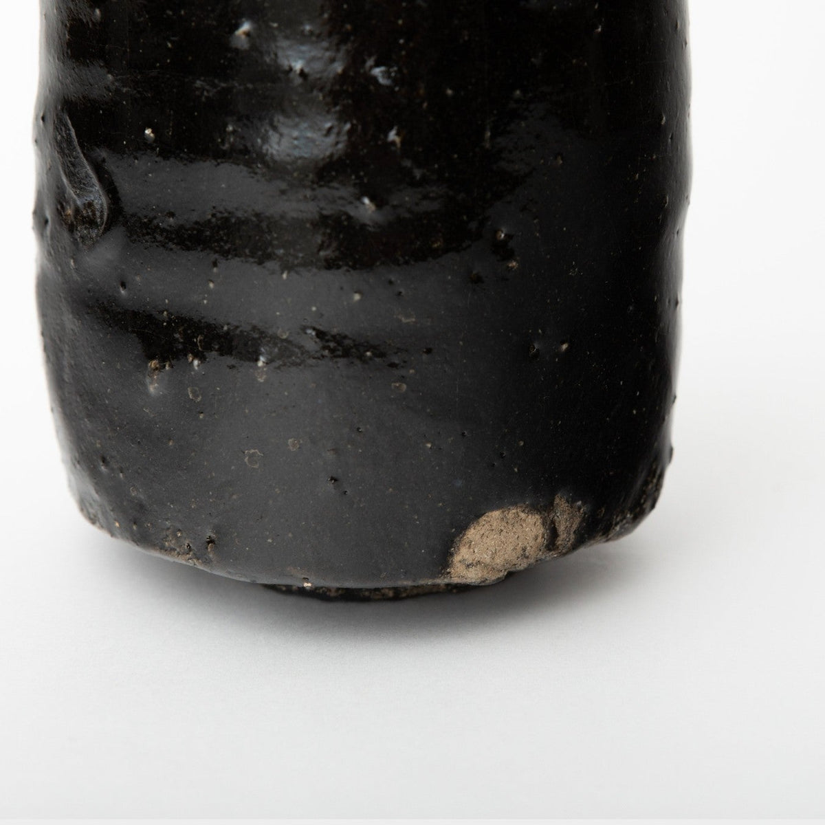 Close view of the foot showing where the glaze stops above a small bare patch of clay.
