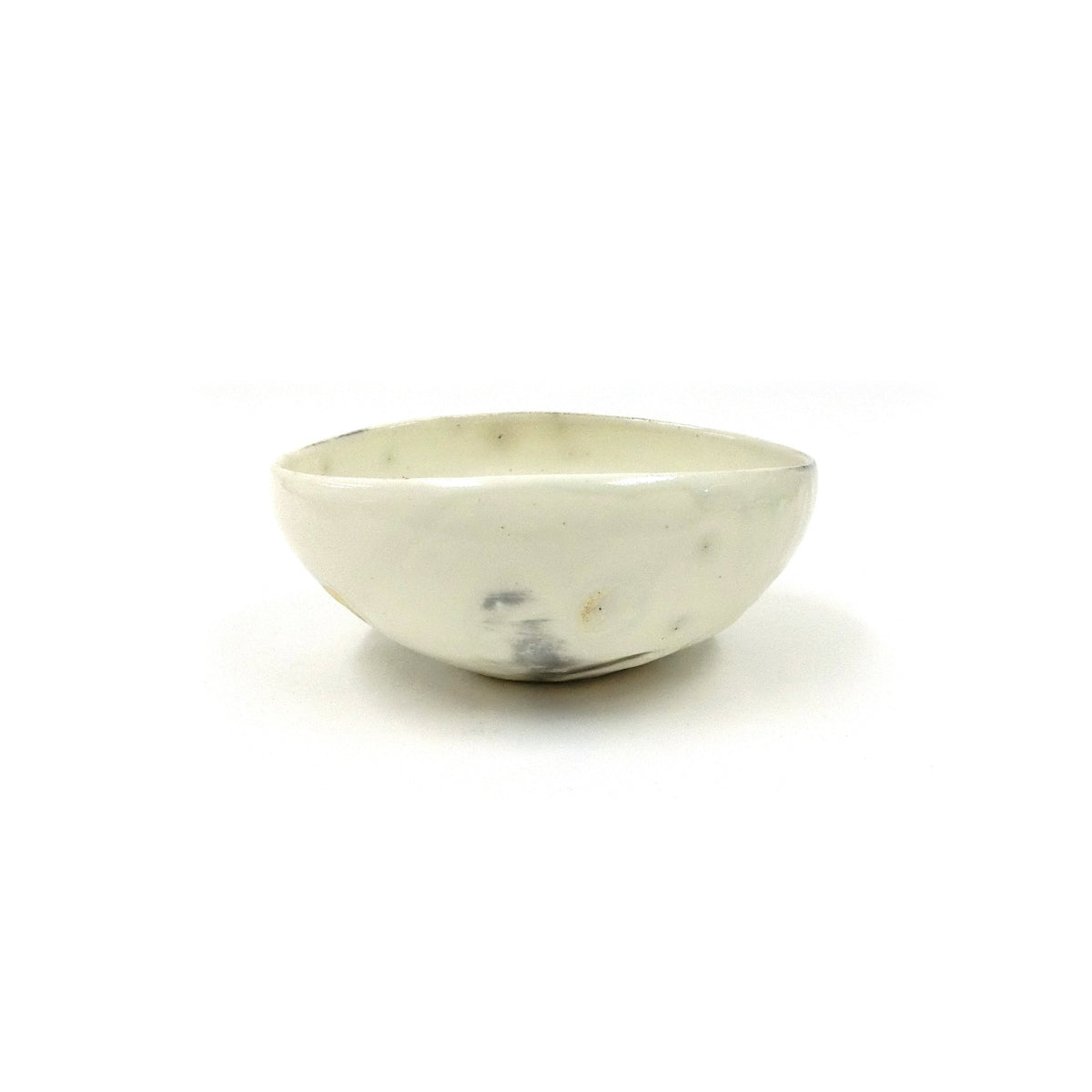Vue de profil de la coupe basse blanche kohiki sur fond blanc, montrant la lèvre doucement ondulante et un point de fer sombre près de la base.