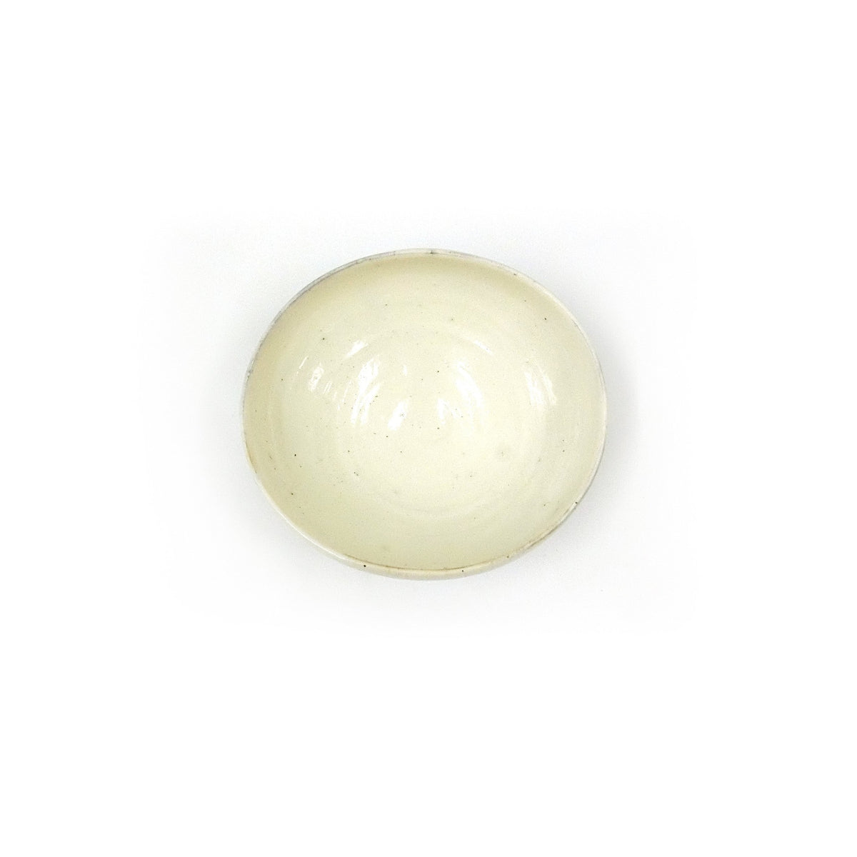 View straight down into the dish, the warm milky glaze and soft crackle filling the shallow well.
