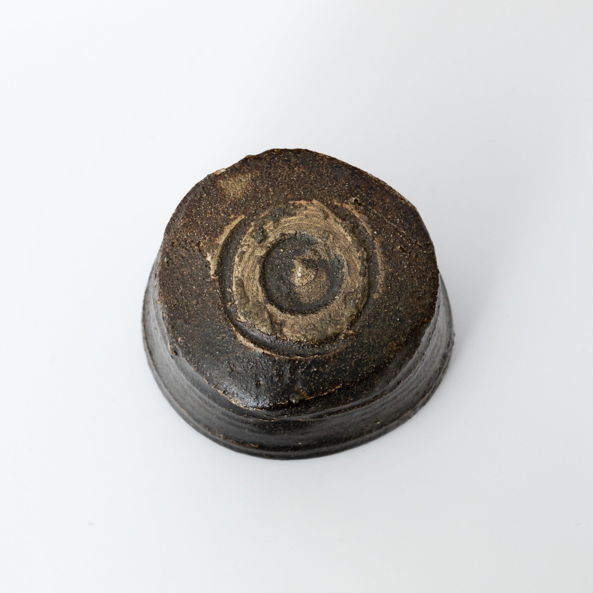 Underside of an Oribe Chawan tea bowl by Kai Tsujimura, showing the earthy foot and carved base details.