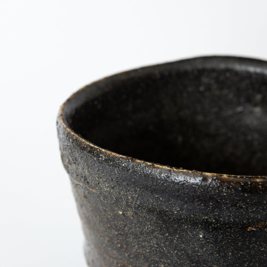Close-up of the rim of an Oribe Chawan tea bowl by Kai Tsujimura, highlighting the dark glaze and fine surface texture.