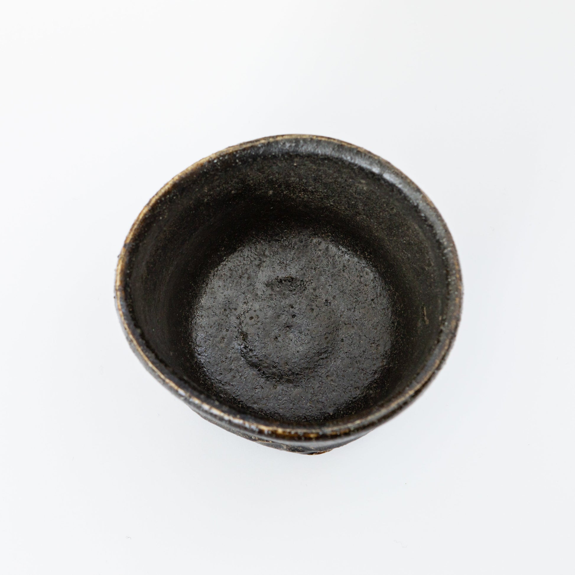 Top view of an Oribe Chawan tea bowl by Kai Tsujimura, showing a deep dark interior and a softly irregular rim.