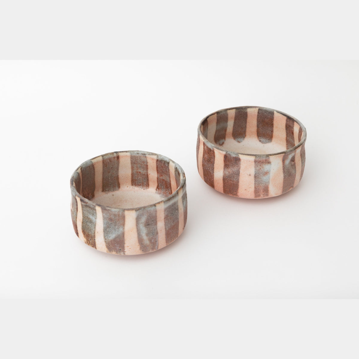 The two dishes seen from slightly above, showing the straight walls and the white interior with a faint pink blush.