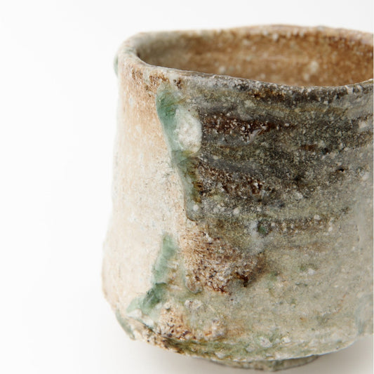 Close side view of the finger ridges and the dark green ash drips on the coarse clay.