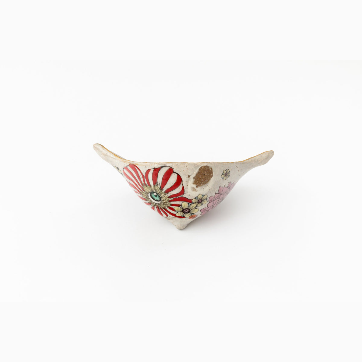 The object seen from the other side, showing a figure in a red-and-white striped dress in overglaze enamel.