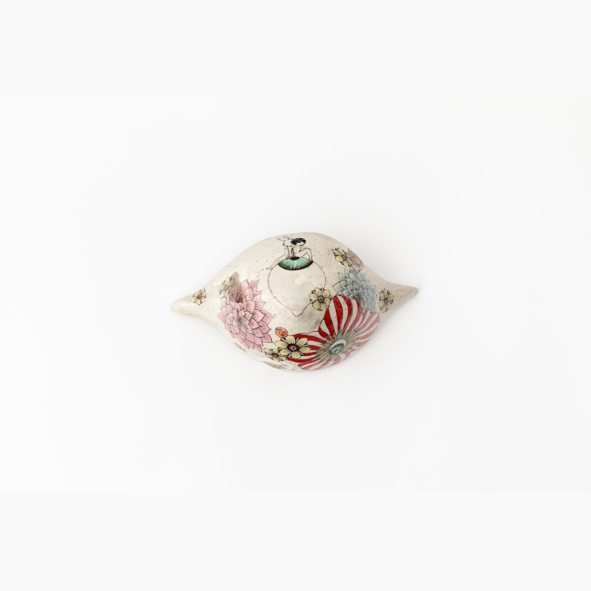 View of the object from one pointed end, the painted red stripes and green leaves curving around the form.