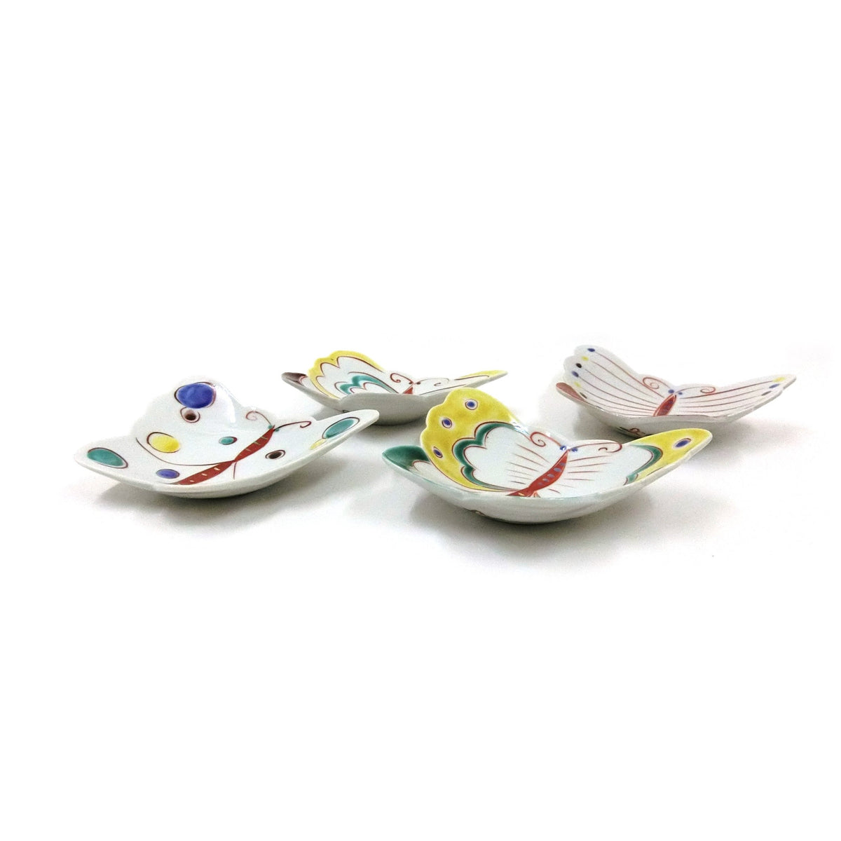 Les six assiettes papillon vues en légère contre-plongée, montrant les ailes doucement relevées.