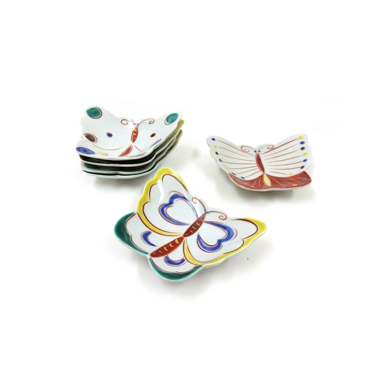Les assiettes papillon librement empilées, une assiette aux ailes jaunes et une rouge et blanche au premier plan.