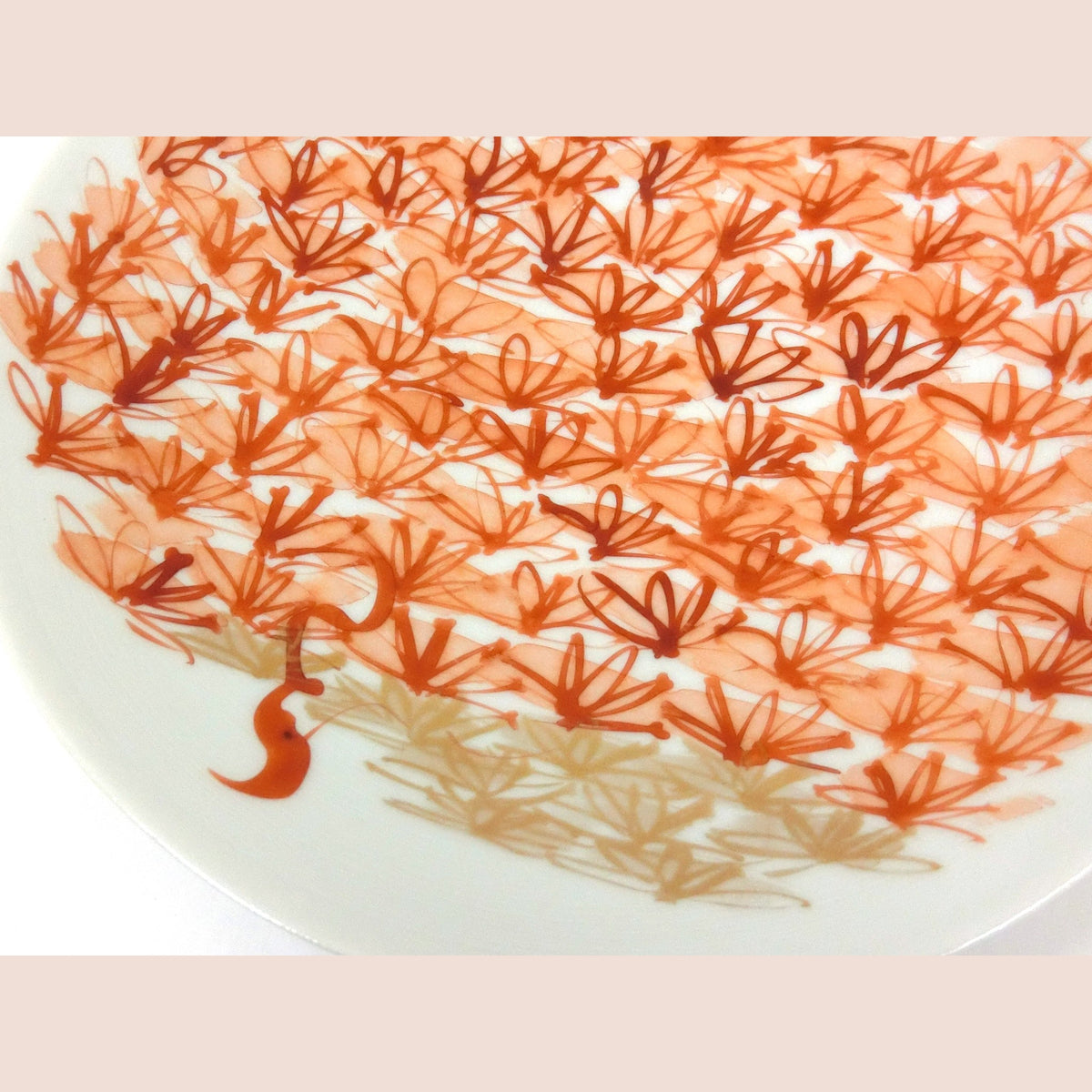 Close detail of the painted flowers, quick red strokes and tiny leaf sprays on the white porcelain.