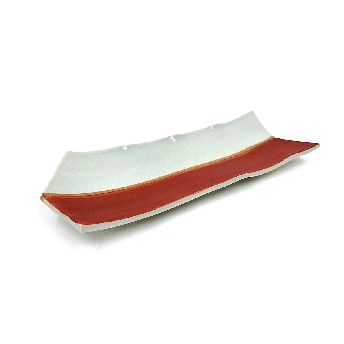 Three-quarter view of the long arrow-feather shaped plate on a white ground, pale celadon top and vermilion red edge.