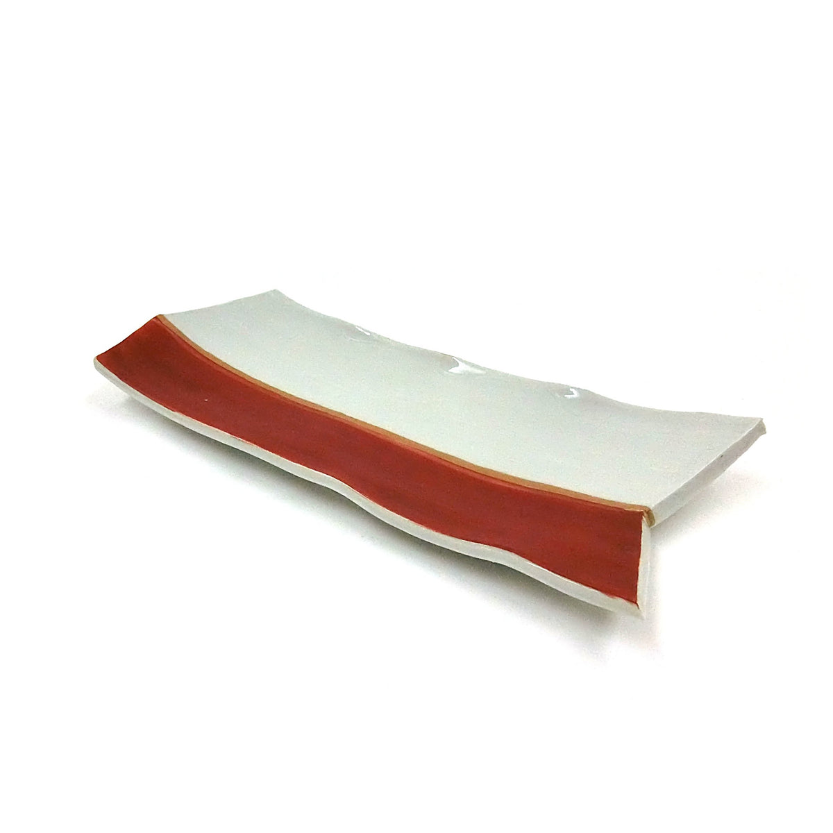 The plate from the other end, red rim and small red dots on the pale surface.