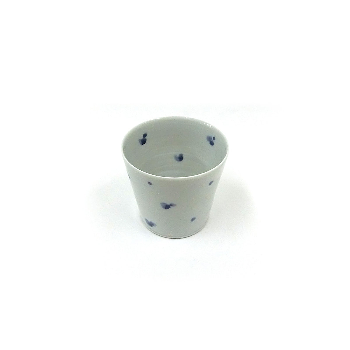 The cup seen from slightly below, its straight walls and faint bluish glaze in even light.