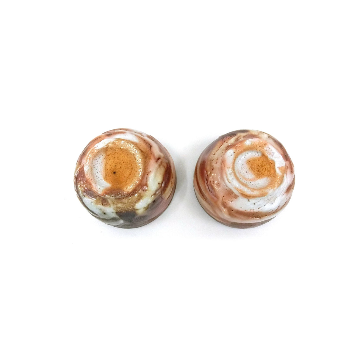 Two cups viewed from above, one with an orange well and one with a marbled grey-white interior.