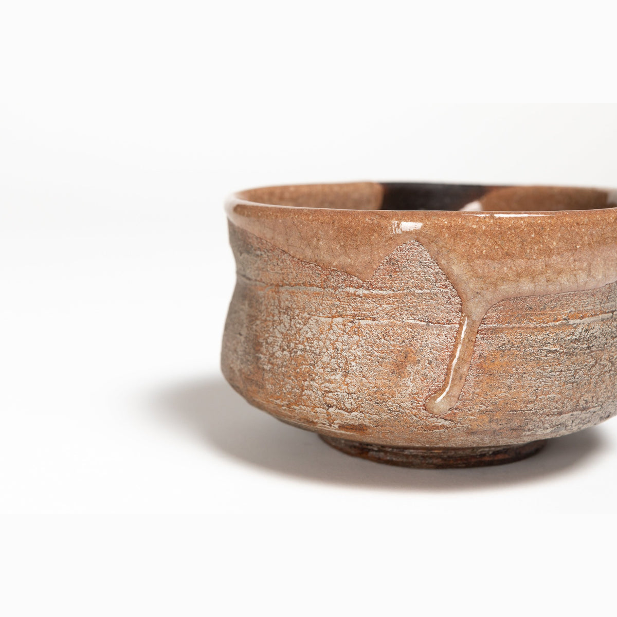 Vue rapprochée de trois quarts de l'épaule et de la lèvre, laque brune à l'intérieur et gris-brun rugueux à l'extérieur.
