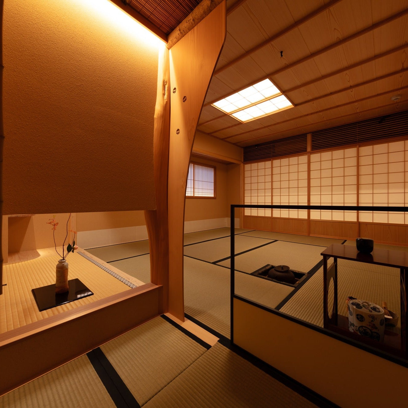 Sunken hearth and tea utensils in the chashitsu beneath a lattice-and-washi ceiling