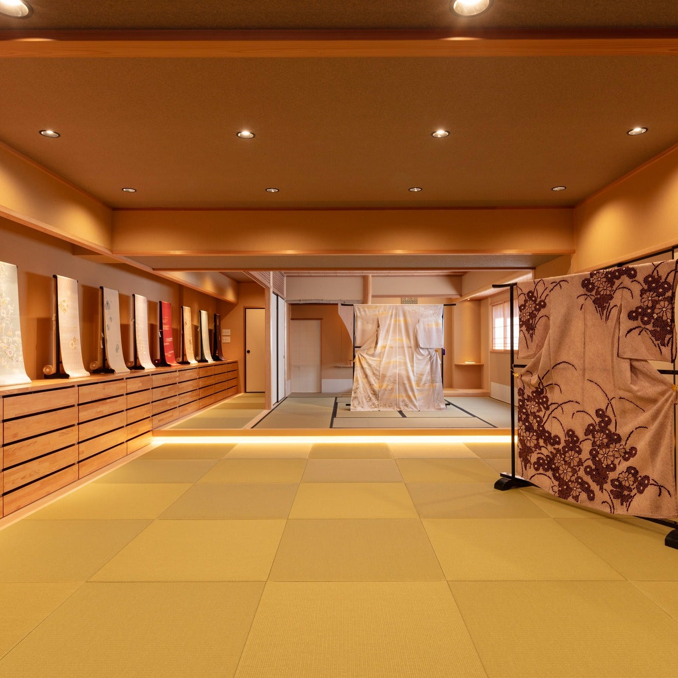 Long tatami gallery lined with obi sashes on stands, a calm work of Japanese architecture