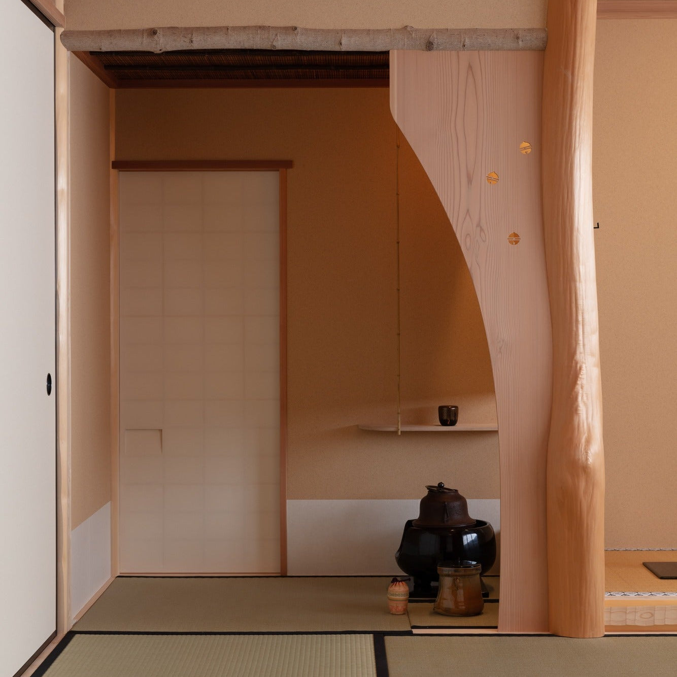 Tea utensils on tatami beside a sculpted post and a frosted sliding door