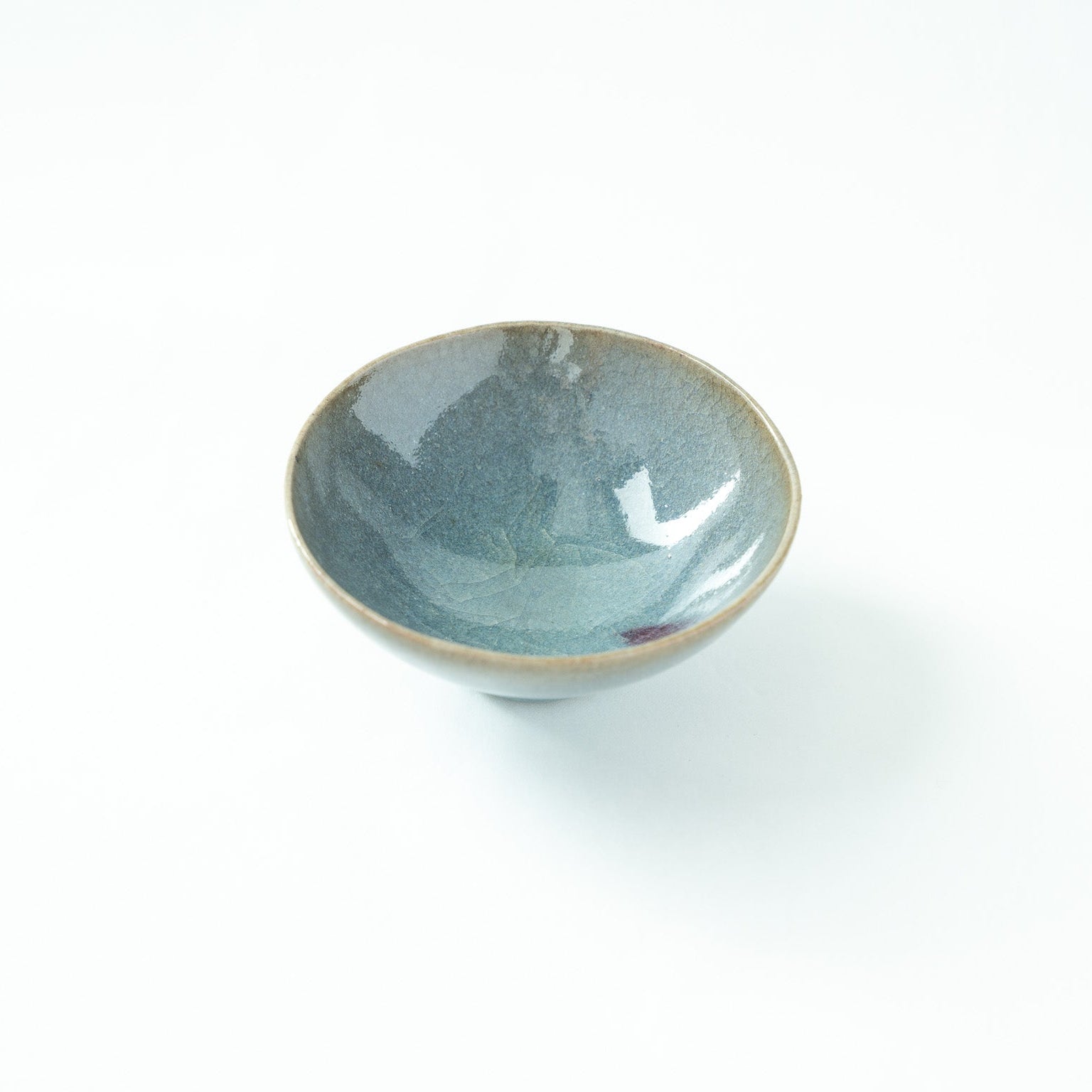Detailed top view of the vessel, showing light catching the fine crackled texture inside the serene blue bowl.