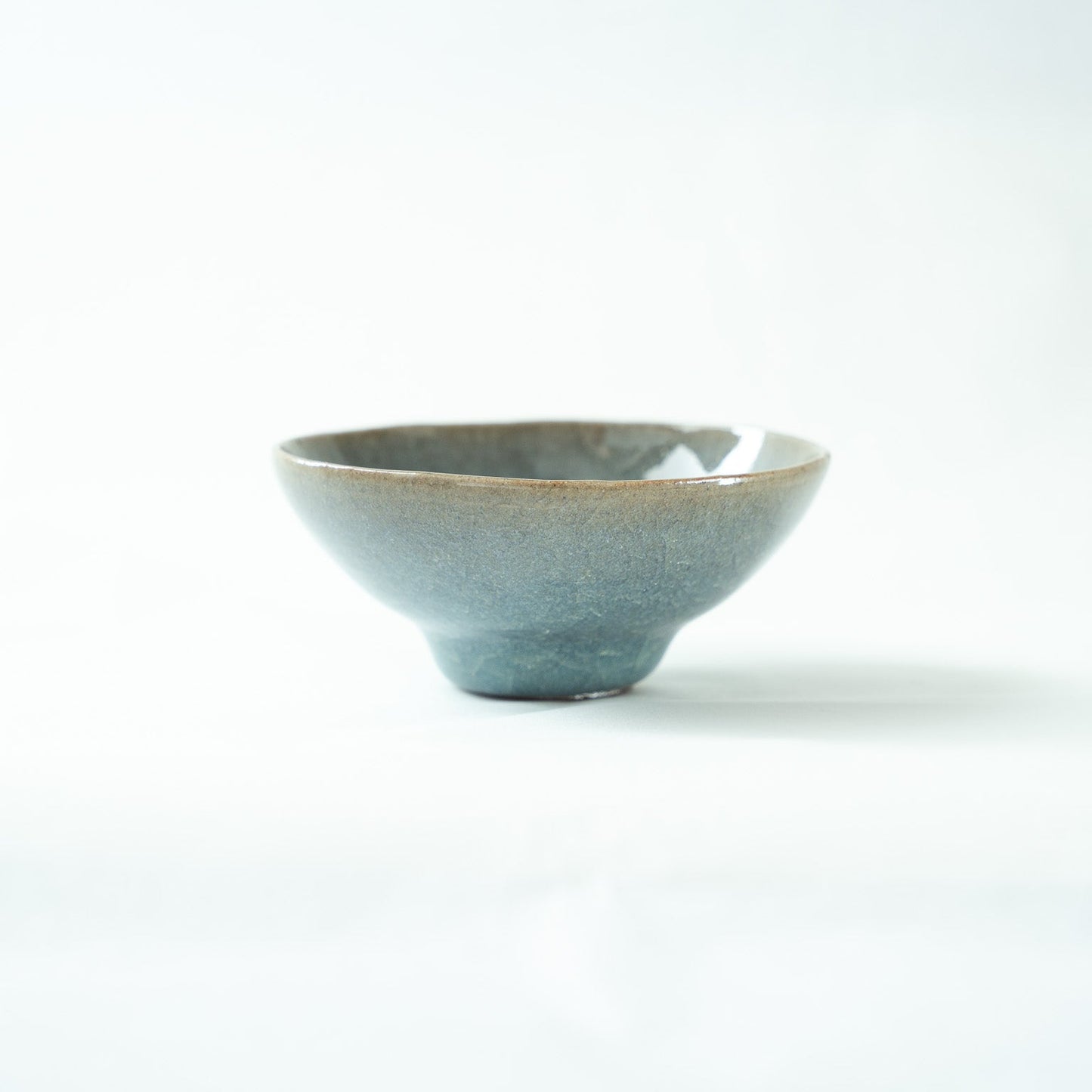 Another profile view of the vessel, showing the delicate crackle patterns running through the pale opaque blue glaze.