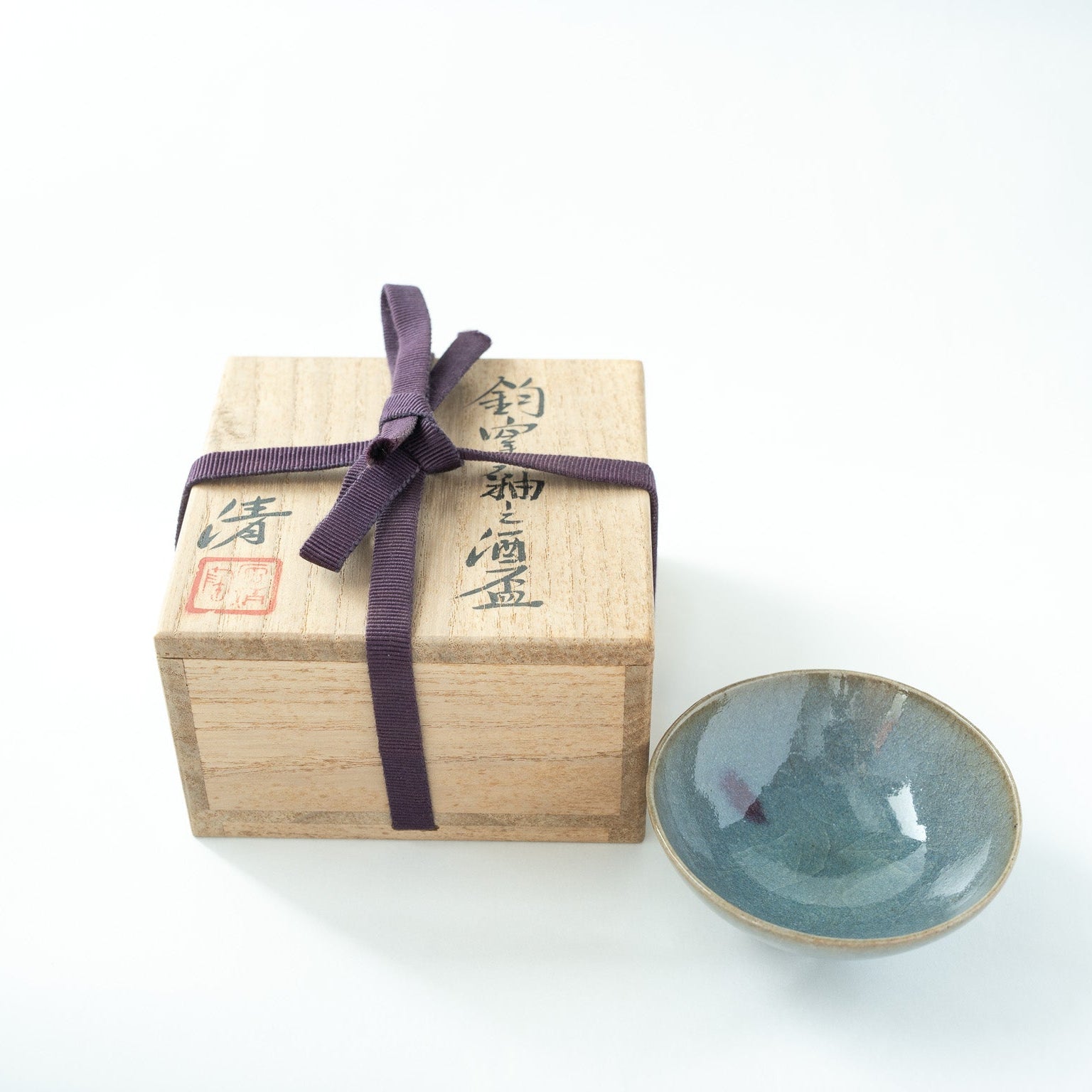 The Choyo-yu sake cup presented next to its original wooden tomobako box, tied with a purple ribbon and signed by Kiyoshi Hara.