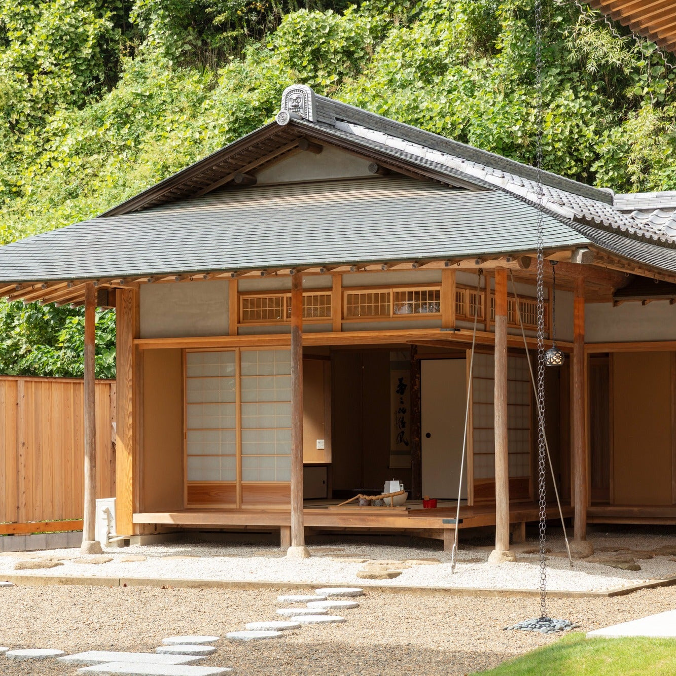 Detached chashitsu opening through shoji onto a dry garden with stepping stones