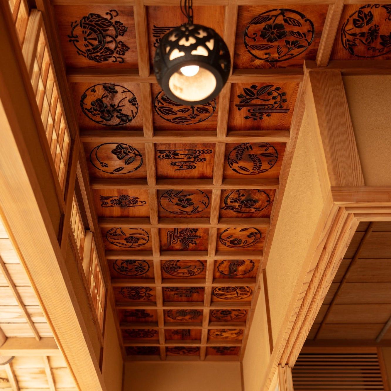 Cedar coffered ceiling with circular floral motifs, a refined detail of Japanese architecture