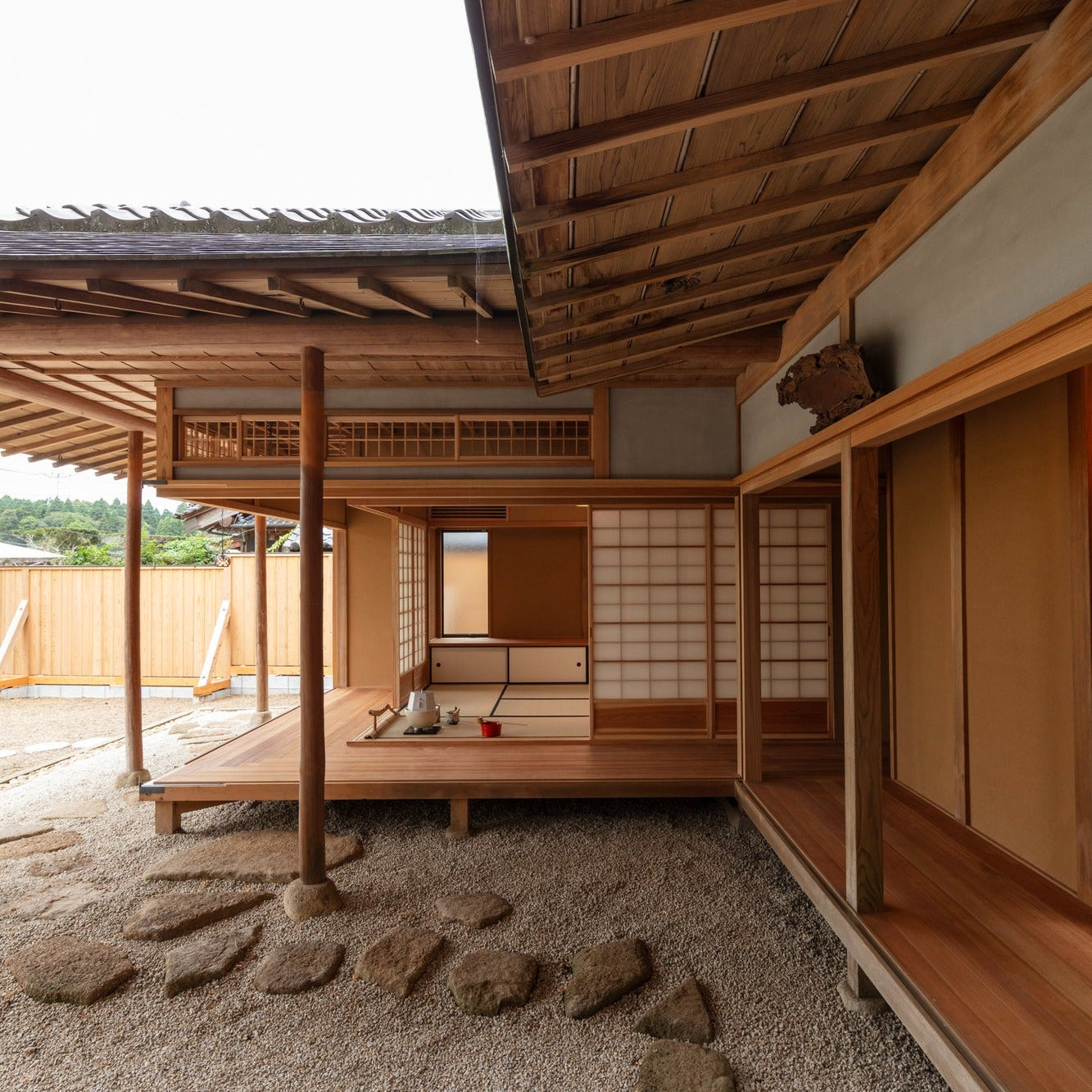Corner of the tea pavilion with deep eaves, a floating deck and a dry stone garden