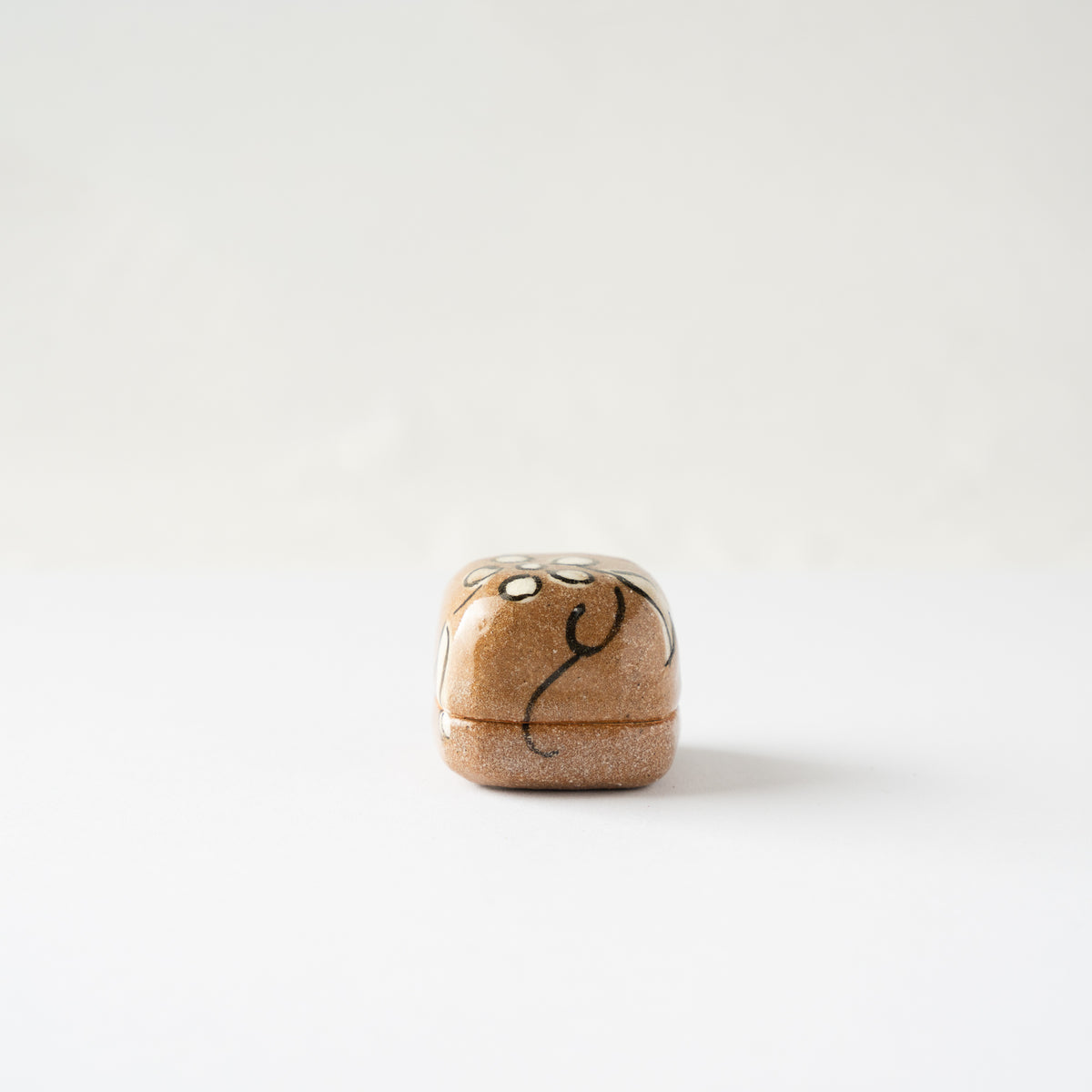 Alternate side view of the miniature Oribe KOGO container, showcasing the soft rounded cubic form.