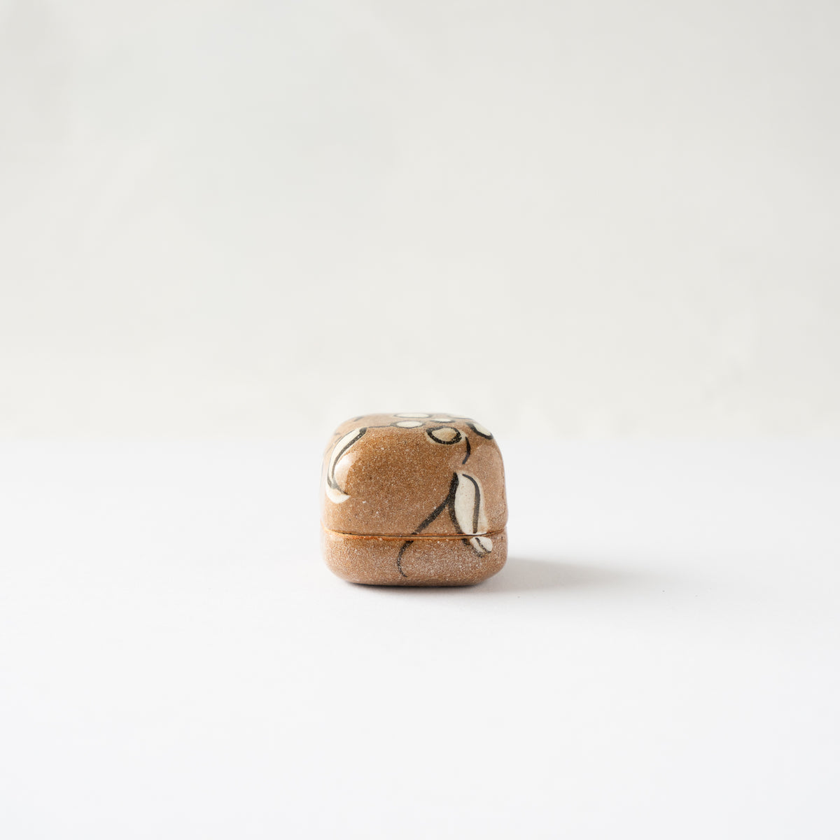Front eye-level view of the closed Oribe ceramic miniature KOGO box, displaying continuous floral patterns across the lid seam.