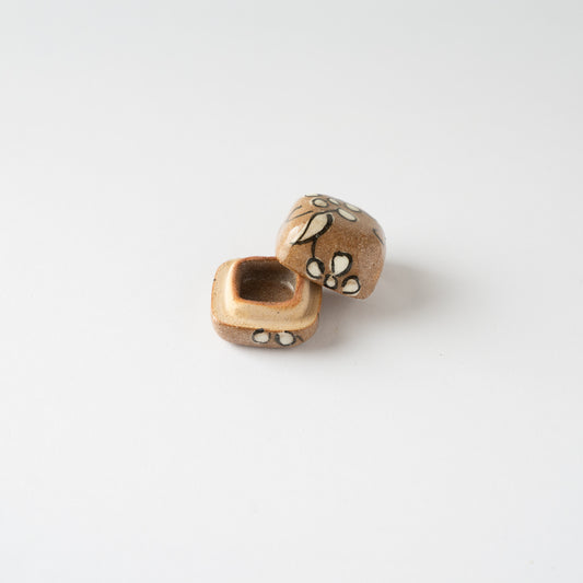 High-angle perspective of the Oribe miniature KOGO incense container with the lid resting open against the body, revealing the inner hollow.