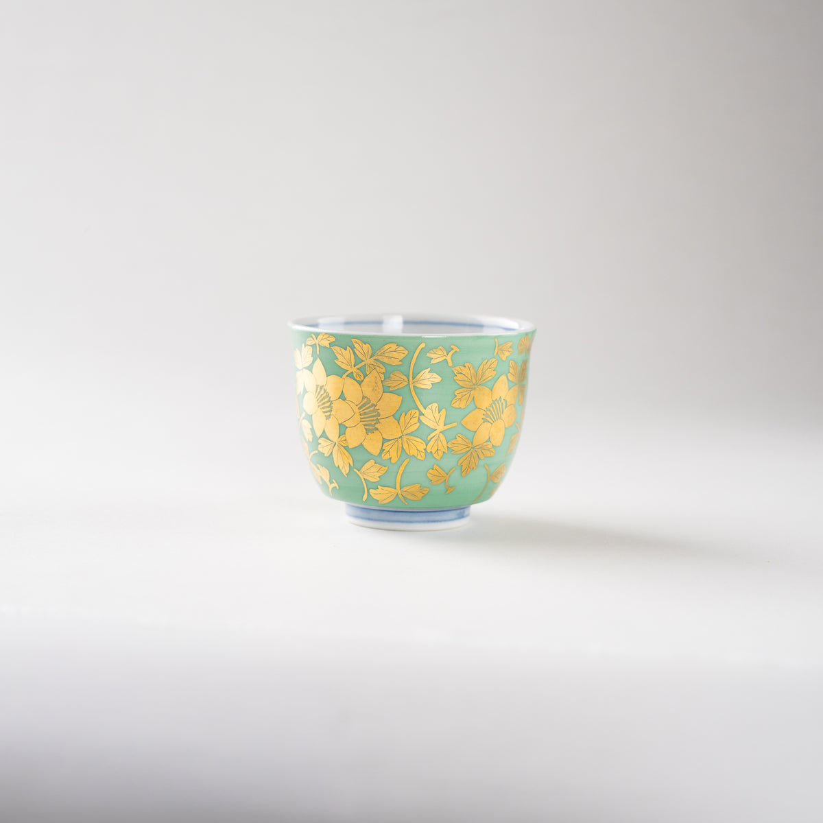 Full eye-level front view of the Kinrande GUINOMI cup by Mitsuru Yoshida, emphasizing its balanced proportions and delicate gold brushwork.