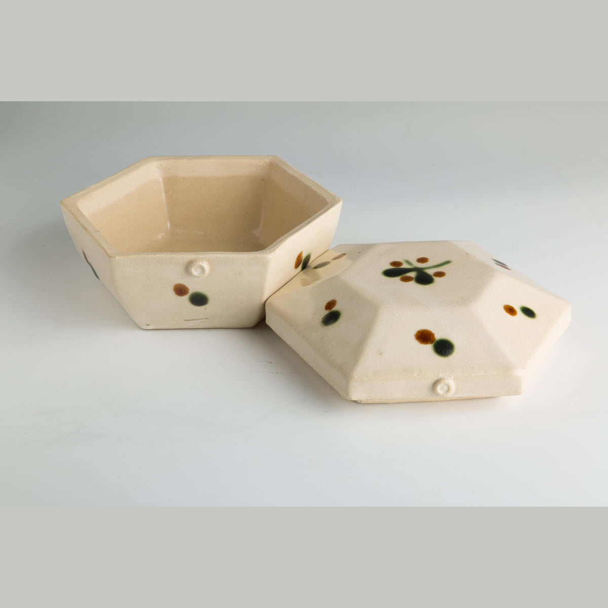 The box with its lid removed and set beside it, showing the plain interior and the dots on the lid.