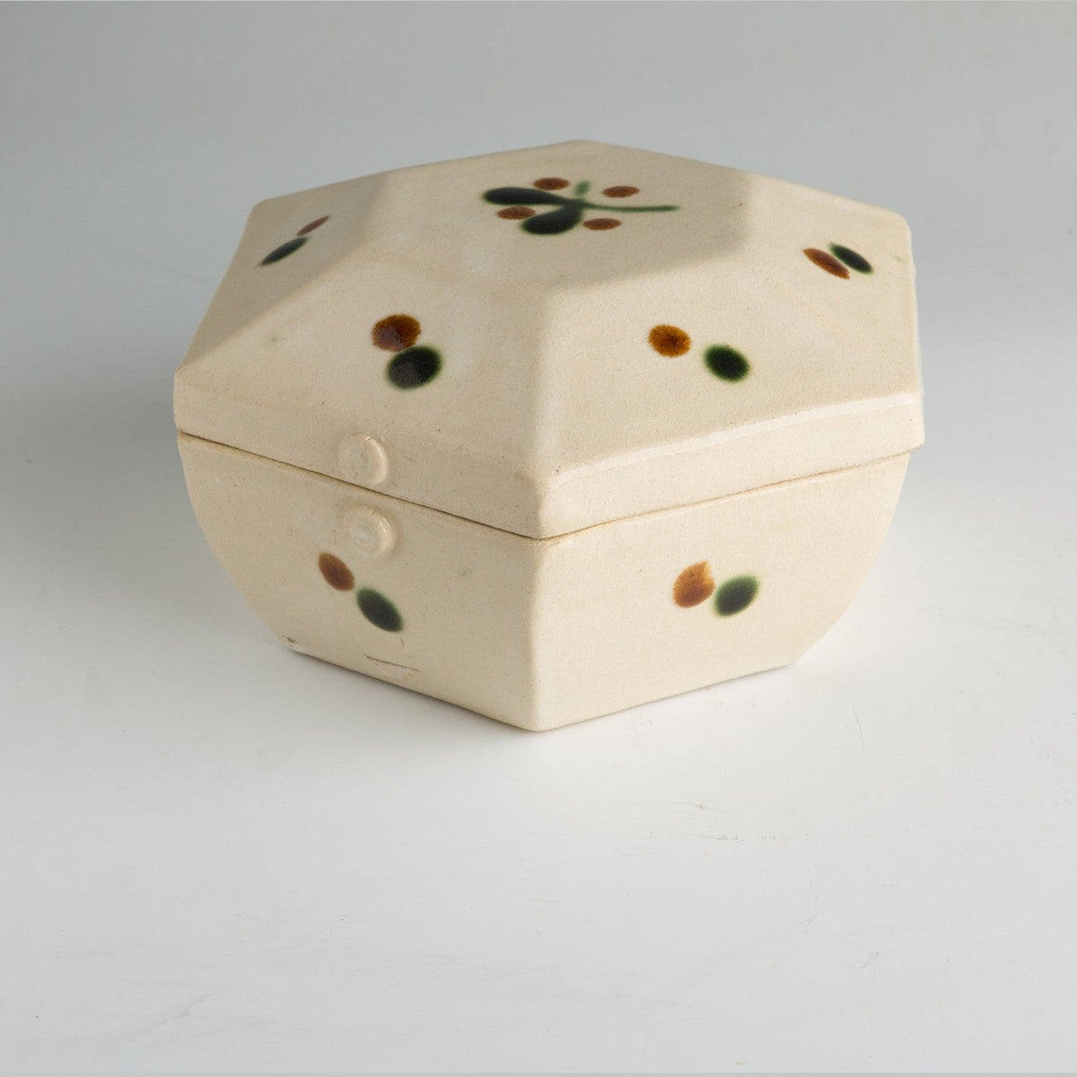 Three-quarter view of the box from above showing the shallow domed lid and the softened corners.