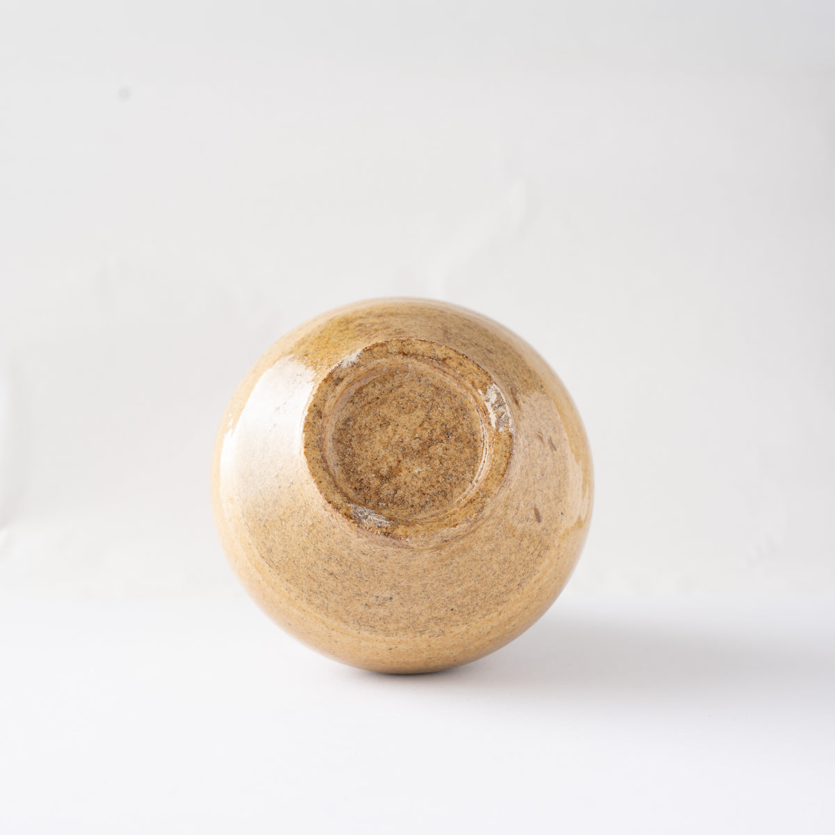 Bottom view of the unglazed circular foot base of Noriyuki Furutani’s yellow glaze TOKKURI sake flask.