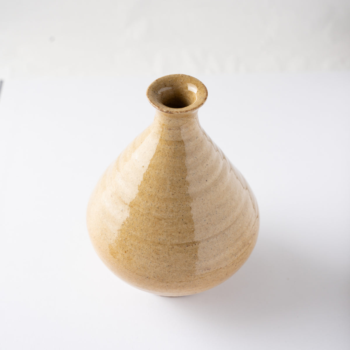 High-angle perspective focusing on the flared rim and slender neck of Noriyuki Furutani’s yellow glaze TOKKURI.
