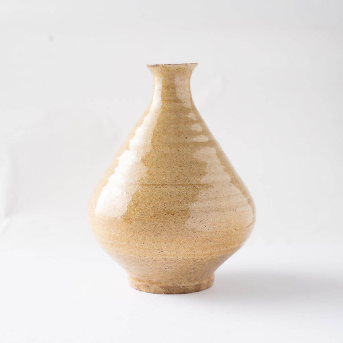 Front view of Noriyuki Furutani’s yellow glaze TOKKURI sake flask, showing its teardrop silhouette and lustrous honey-colored glaze.